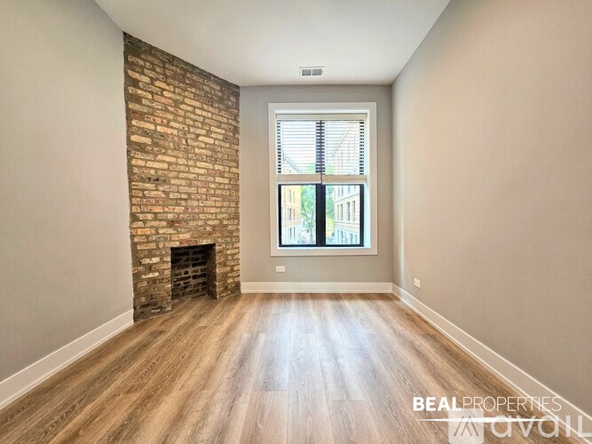 A room with a brick fireplace and wooden flooring.