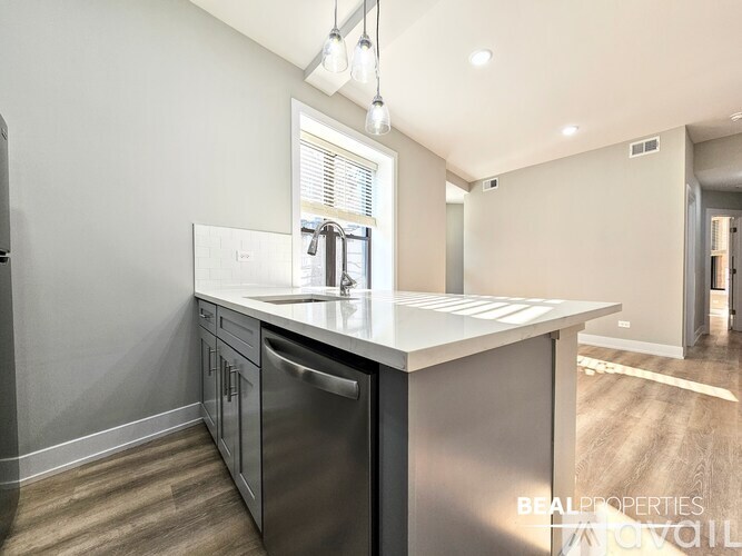 A modern kitchen with a stainless steel dishwasher and a window letting in natural light.