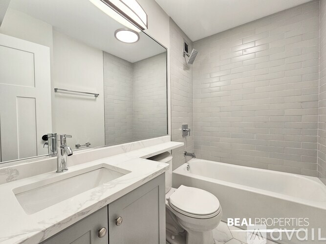 A white bathroom with a toilet, sink, and tub.