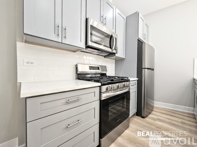 A modern kitchen with a stove, microwave, and refrigerator.