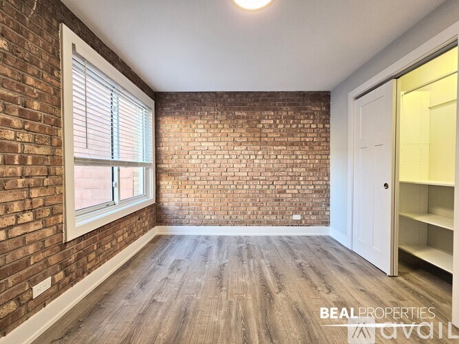 A room with a brick wall and wooden flooring.