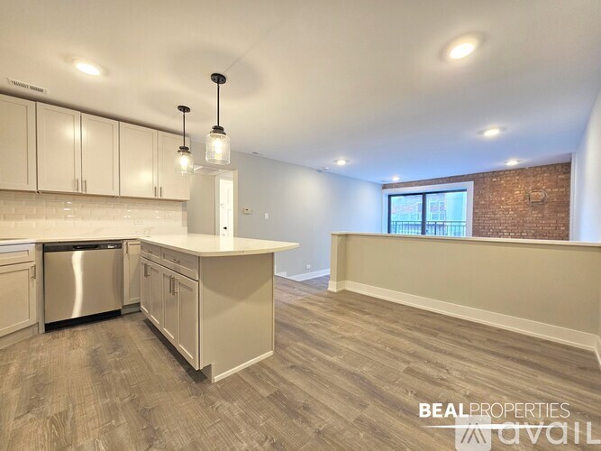 A spacious room with wooden flooring and a white door.
