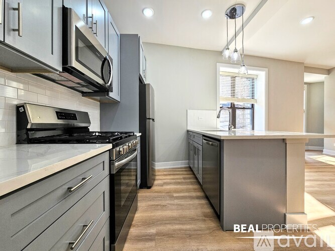 A modern kitchen with stainless steel appliances and a large island.