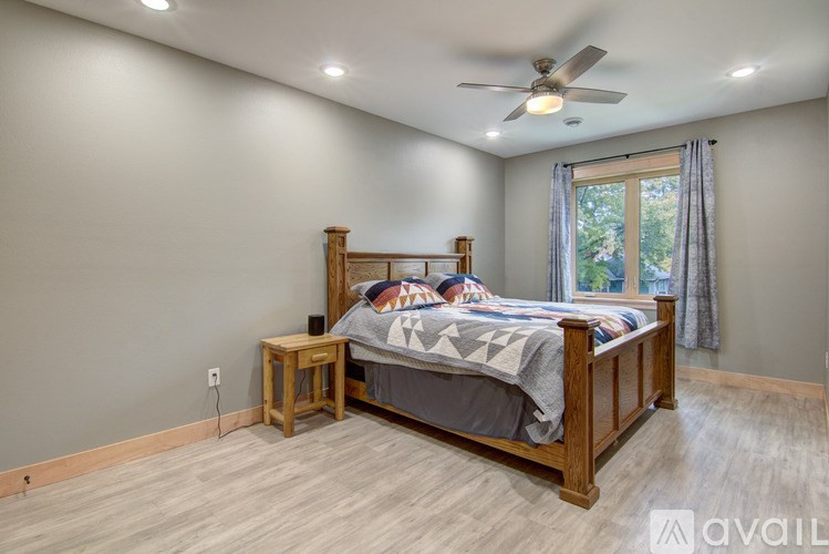 A bedroom with a bed, nightstand, and window.