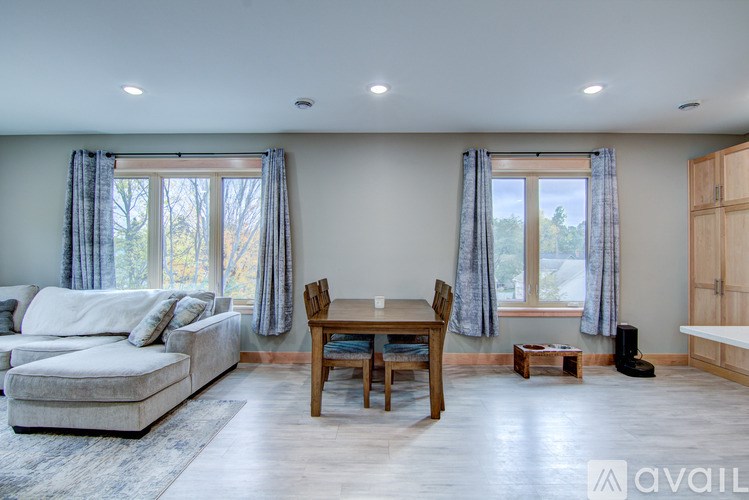 A living room with a couch, table, and chairs.