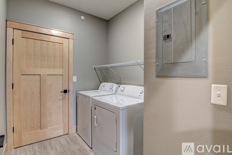 A laundry room with a washer and dryer and a wooden door.