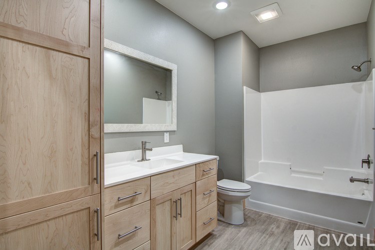 A bathroom with wooden cabinets and a white sink.