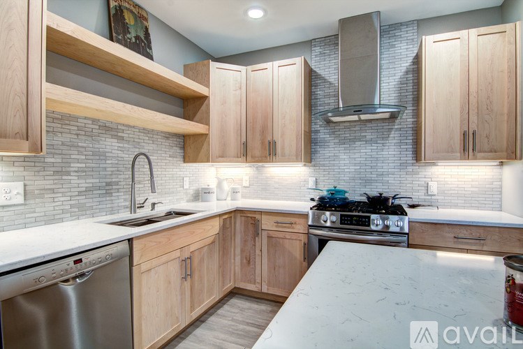 A kitchen with wooden cabinets and a stainless steel dishwasher.
