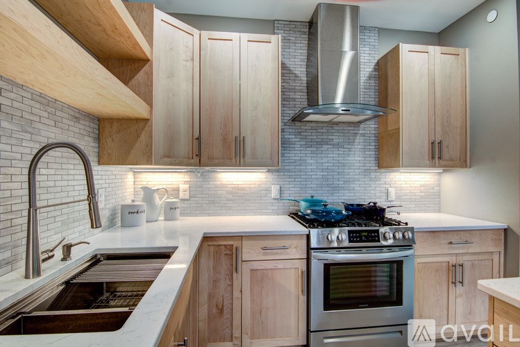 A kitchen with wooden cabinets and a stainless steel range hood.