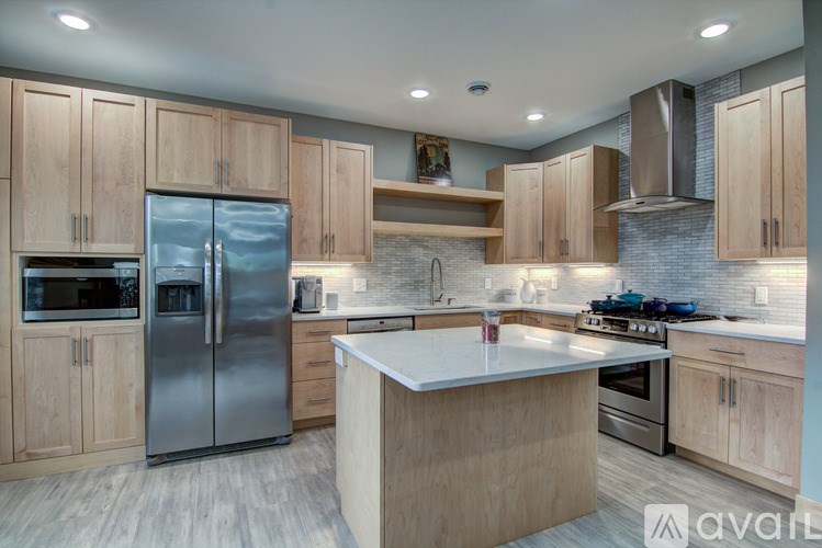 A modern kitchen with wooden cabinets and stainless steel appliances.