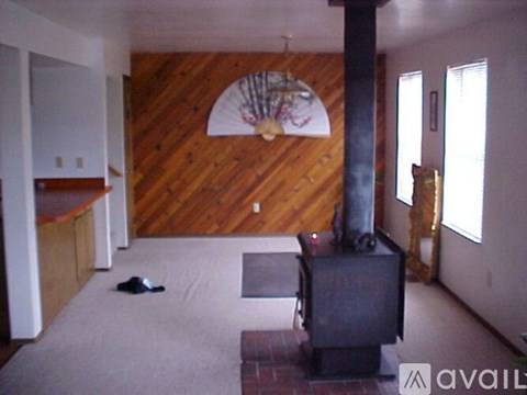 A room with wood paneling and a fan on the wall.