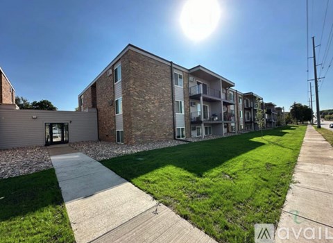 A sunny day at a residential area with apartment buildings and a sidewalk.