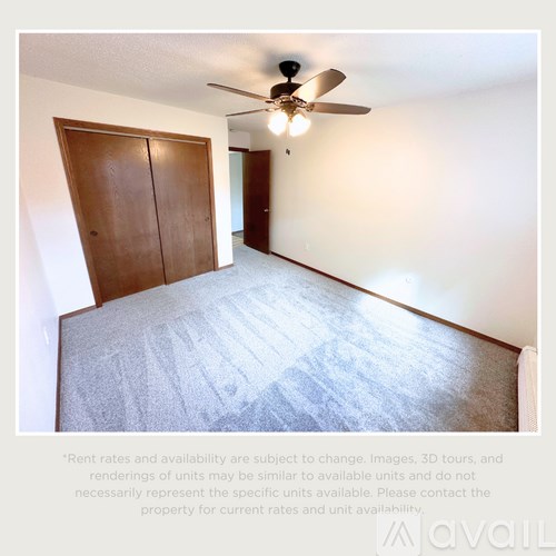 A room with a ceiling fan and two doors.