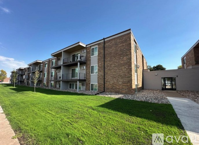 A row of modern apartment buildings with green lawns in front.