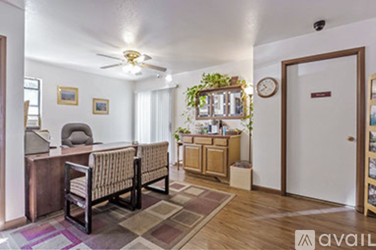 A living room with a couch, chair, and a plant on the windowsill.