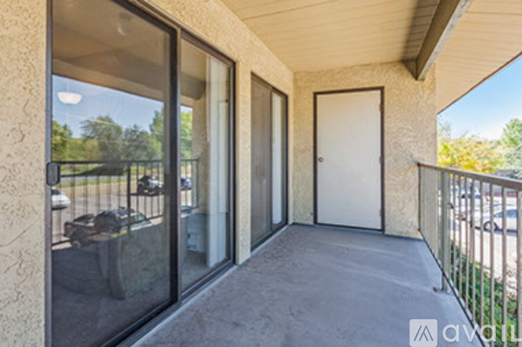 A balcony with a white door and sliding glass doors.