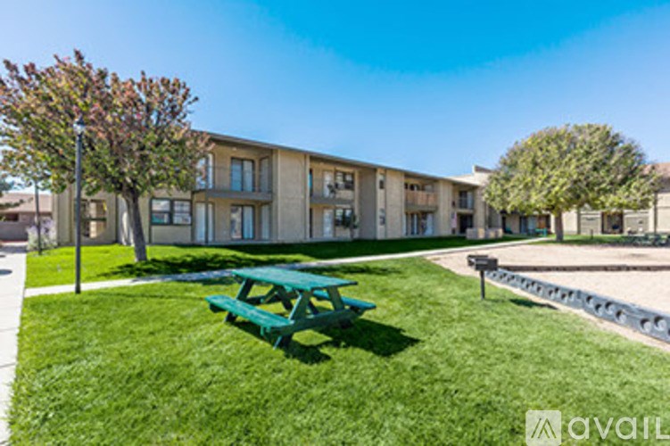 A green picnic table is in front of a building.