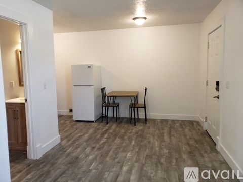 A kitchen area with a table and chairs and a refrigerator.