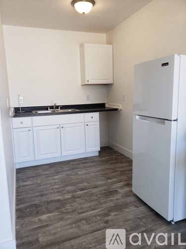 A kitchen with a white fridge and cabinets.