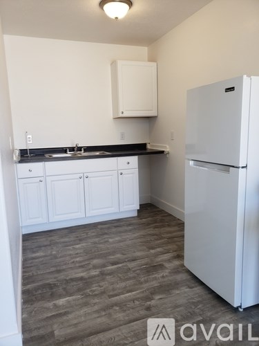 A kitchen with a white fridge and cabinets.