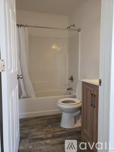 A white toilet in a bathroom with a wooden cabinet.