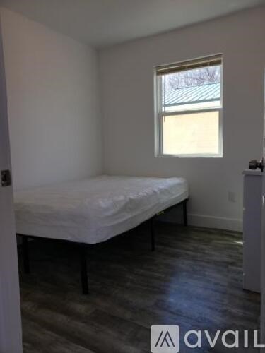 A bedroom with a bed and a window.