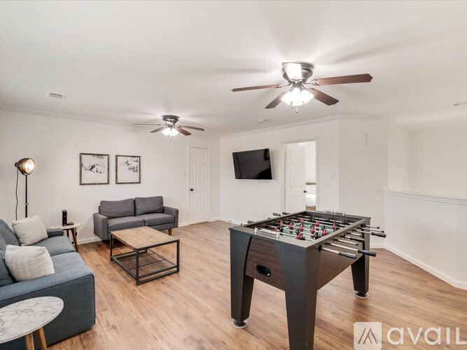 A living room with a foosball table in the middle.