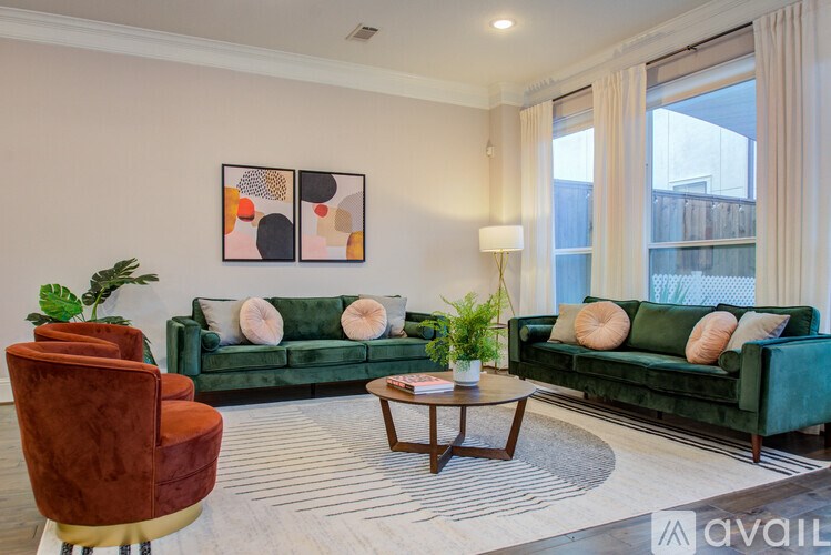 A living room with a green couch, a brown chair, and a coffee table.