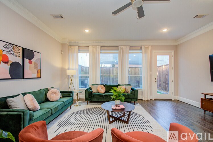 A living room with a green couch, a coffee table, and a painting on the wall.