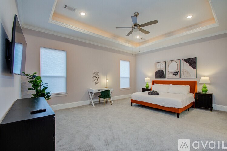 A bedroom with a bed, a chair, and a television.
