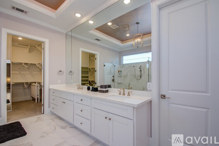 A bathroom with a vanity, mirror, and a chandelier.