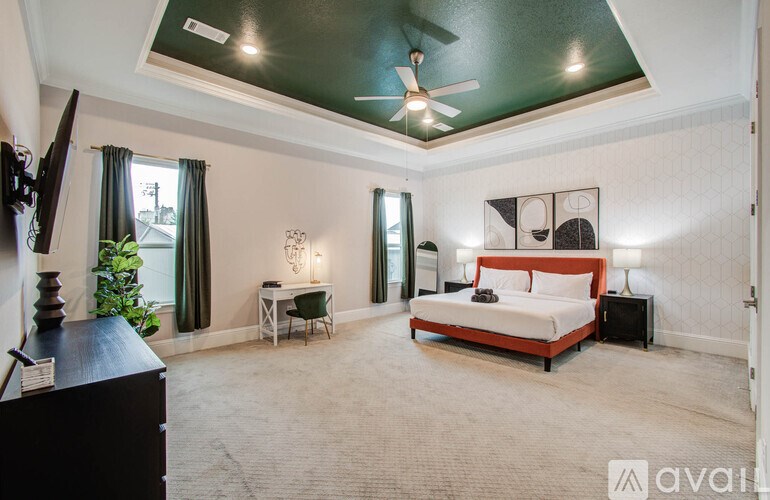 A bedroom with a bed, desk, and chair.