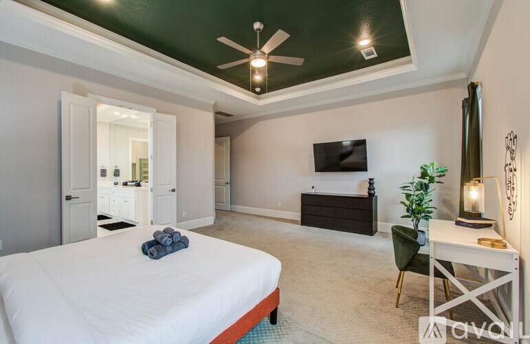 A bathroom with a white vanity and a large mirror.