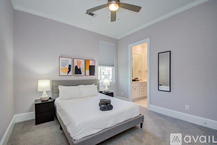 A bedroom with a bed, nightstand, and a ceiling fan.