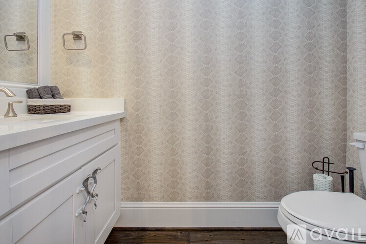 A white toilet sits next to a white sink in a bathroom.