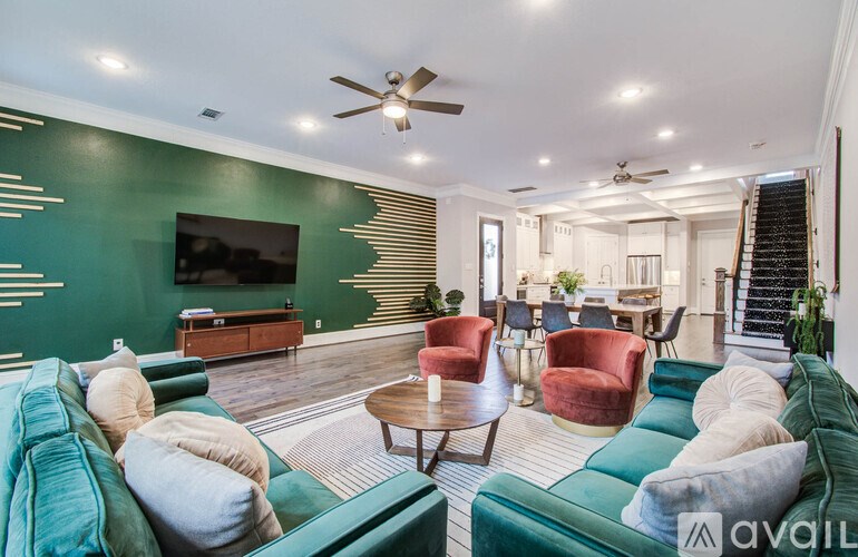 A living room with a green couch, a red chair, and a television.