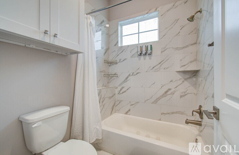 Two glasses of wine and a bottle are on a table with a fire in the background.