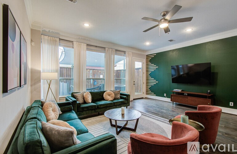A dining room with a wooden table and chairs, a staircase, and a painting on the wall.