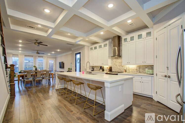 A kitchen with white cabinets and a large island.