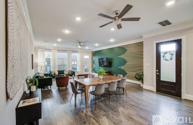 A modern kitchen with white cabinets and a wooden floor.