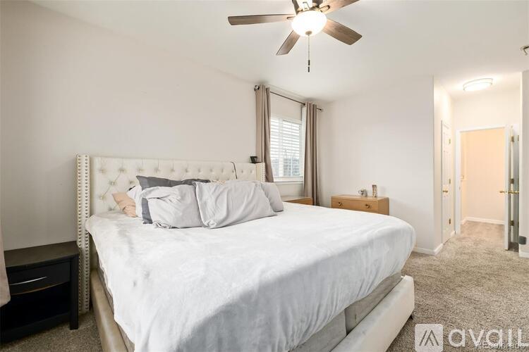 A bedroom with a large bed and a ceiling fan.