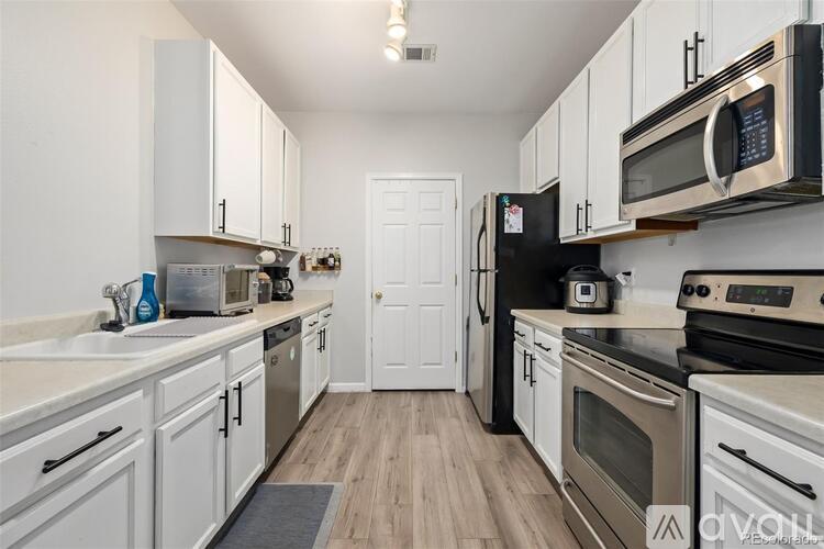 A kitchen with white cabinets and black appliances.