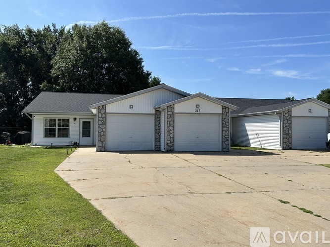 A large white house with a garage is available for rent.