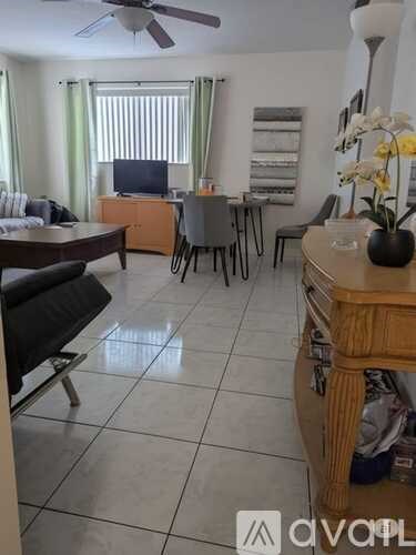 A living room with a dining table and chairs.