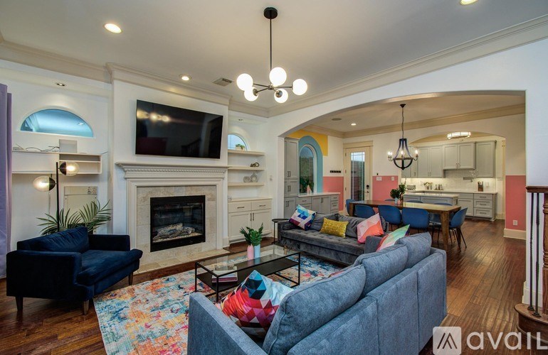 A living room with a grey couch, a black coffee table, a fireplace, and a television.