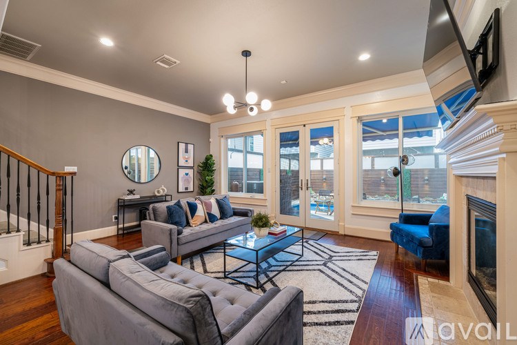 A living room with a grey couch and a fireplace.