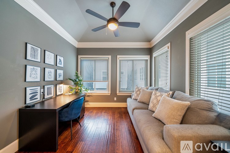 A living room with a couch, a chair, a table, and pictures on the wall.