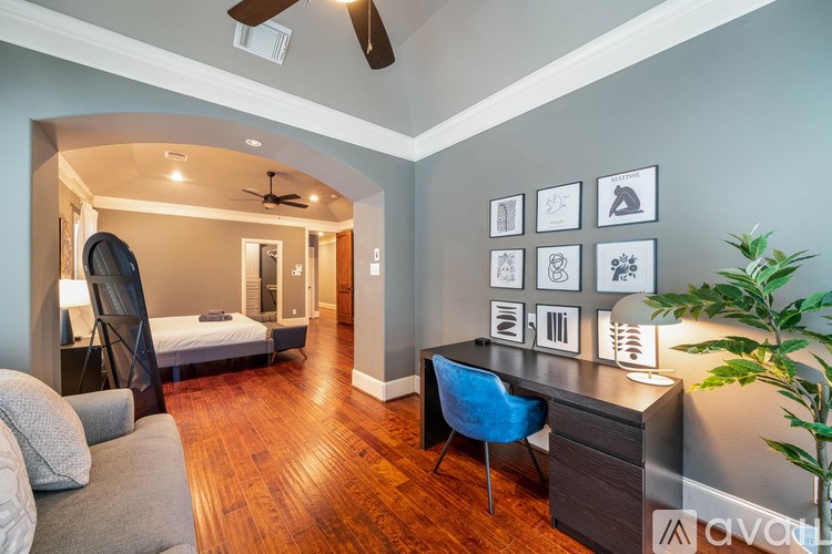 A room with a bed, desk, and chair.