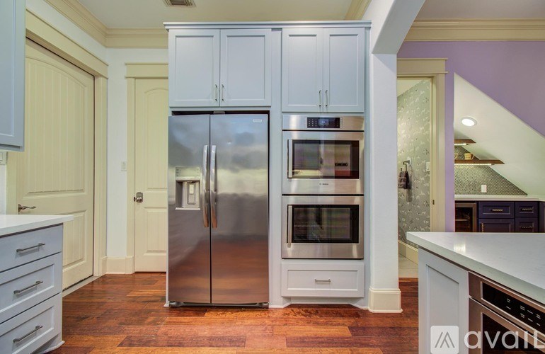 A bathroom with a tub, shower, and window with blinds.