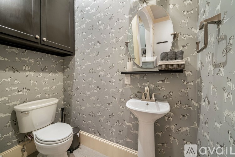 A bathroom with a toilet, sink, and a mirror.